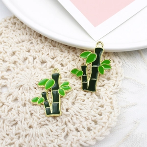 Detailed macro view of two green enamel bamboo pendants with gold plated frames