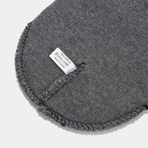 Detail of 100% acrylic gray knitted beanie showing washing label and inner stitching