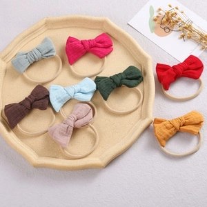Close-up of soft cotton linen bow headbands for babies in eight vibrant colors with nylon bands