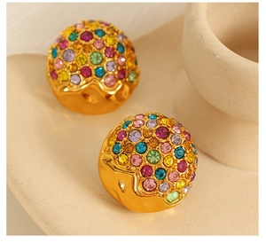 Macro view of gold hemisphere earrings with colorful rhinestones and sparkling gems