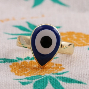 Vue macro d'une bague goutte dorée avec œil protecteur en émail bleu poli