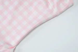Detailed close-up of high-quality pink and white checkered fabric with clear texture