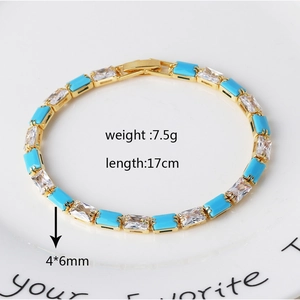Macro shot of gold bracelet featuring alternating turquoise and clear zircon stones