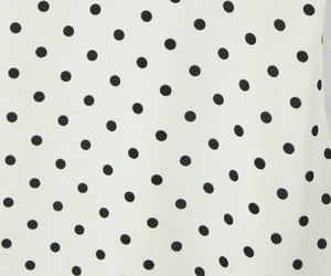 Vista macro della stampa a pois bianchi su tessuto in poliestere liscio per abiti estivi