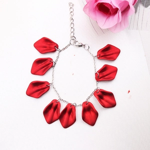 Detailed view of bohemian bracelet featuring red flower petals on a silver chain