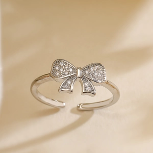 Close-up of a silver bow knot open ring with micro-pave cubic zirconia inlay detail
