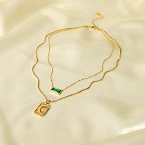 Double-layered gold necklace with green rectangle pendant and crescent moon engraving
