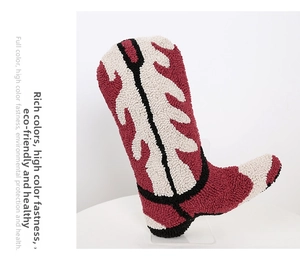 Detail of tufted cowboy boot pillow showing thick red and cream textured fabric surface