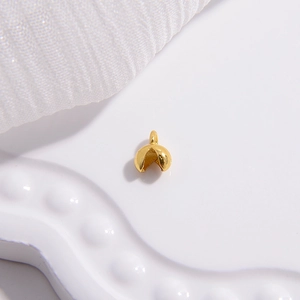 Vue détaillée d'un pendentif biscuit de fortune doré poli sur un plateau blanc décoratif