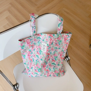 Close-up of floral cotton tote bag with pink flower pattern on a white chair