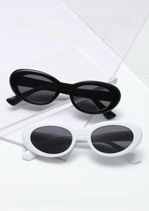 Close-up of trendy black and white oval sunglasses on a minimalist geometric display stand