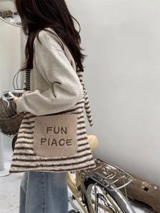 Close-up of winter fuzzy striped tote bag with FUN PIACE embroidery in outdoor setting