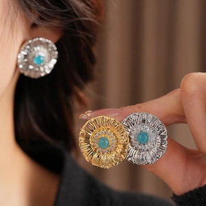 Close-up of vintage flower earrings featuring turquoise stones and crystal accents