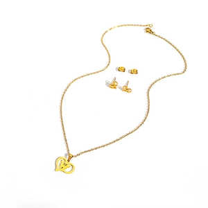 Detailed view of a gold-tone stainless steel jewelry set featuring heart pendants and studs