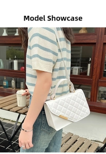 Outdoor shot of a woman wearing a white quilted crossbody bag with gold hardware detail