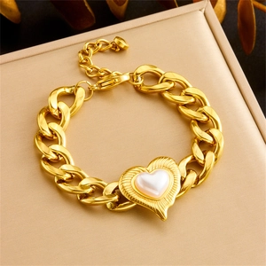 Gold chain bracelet with textured heart pendant and pearl inlay on a beige display box