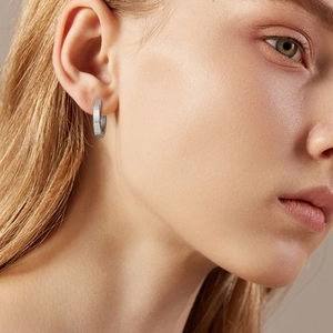 Close-up of geometric octagonal silver earrings with a modern polished metallic finish
