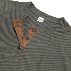 Detailansicht eines olivgrünen Henley-Shirts mit brauner Veloursleder-Knopfleiste und Waffelstruktur