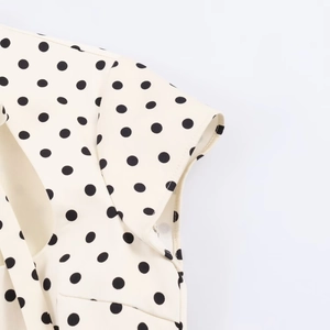 Détail de la robe courte crème avec imprimé à pois noirs et coutures de précision