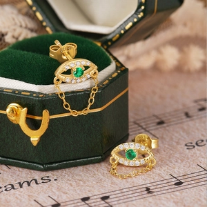 Detail of S925 sterling silver evil eye stud with green zircon and tassel chain