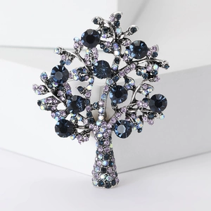Elegant silver money tree brooch featuring vibrant blue and purple crystals on white pedestal