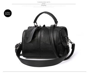 Details der schwarzen Boston-Tasche aus Kunstleder mit Schleife und Metallteilen