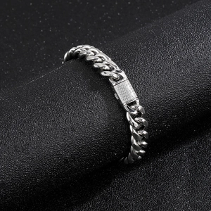 Detailed macro view of silver Cuban chain with diamond-encrusted rectangular clasp buckle
