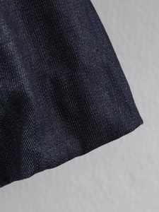 Detailed macro view of dark blue denim fabric texture and durable twill weave pattern
