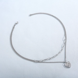 Detail of silver double-layered heart necklace with paperclip chain and engraved words