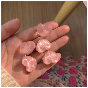 Close-up of five heart-shaped pink hair clips with a glossy ice-crackle texture