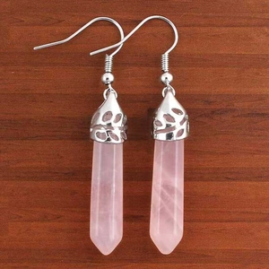 Dettaglio orecchini a prisma in quarzo rosa con ganci in argento su legno