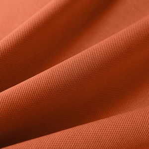 Macro shot of breathable brick red golf polo shirt fabric with fine mesh texture