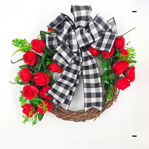 Detail view of a 45cm Christmas wreath with red roses, green leaves and plaid bow
