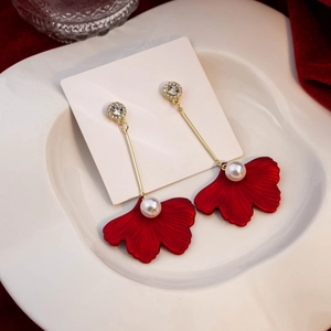 Elegant red leaf long pearl drop earrings with sparkling rhinestones in a white ceramic dish