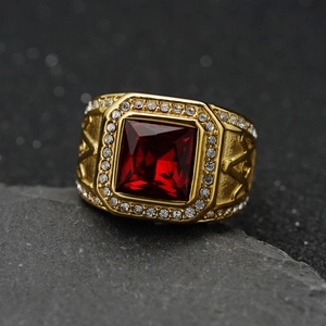 Gold stainless steel Masonic ring with square red gemstone on black volcanic rock