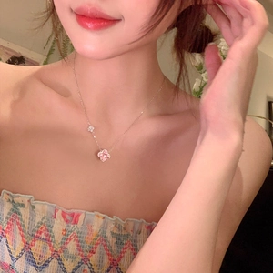 Pink clover pendant necklace on model showing delicate chain and feminine style