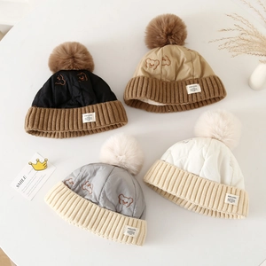 Détail de quatre bonnets tricotés d'hiver colorés avec pompons et doublure polaire douce