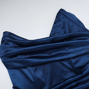 Detailed macro view showing the smooth texture and pleated neckline of navy satin dress