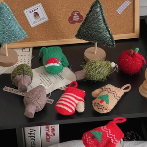 Flat lay of handmade knit Christmas tree ornaments and festive decorations on corkboard
