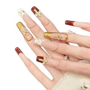 Faux ongles rose et bordeaux avec croix dorées et motifs marbrés élégants