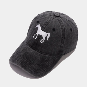 Close-up of white horse embroidery and stitching on a washed cotton baseball cap