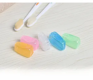 Close-up of five colorful portable toothbrush head covers on a wooden surface