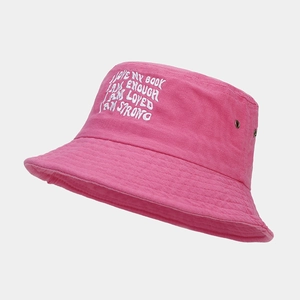 Detail of pink canvas bucket hat featuring white embroidery and metal ventilation eyelets