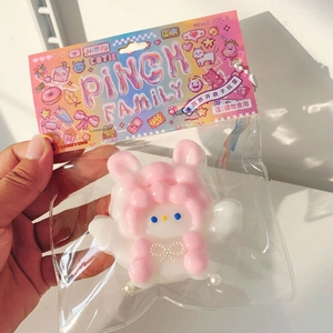 Soft pink rabbit squishy stress relief toy in sealed packaging with illustrated card