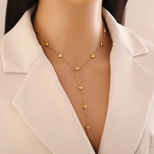 Collier élégant doré en forme de Y avec cœurs et pendentif long porté par modèle