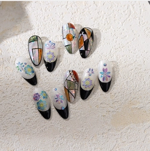 Macro detail of floral and cat-eye nail art stickers with geometric patterns