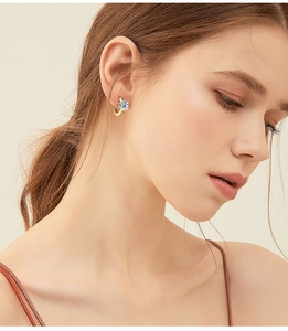 Close-up of elegant gold six-prong moissanite hoop earring worn by a female model