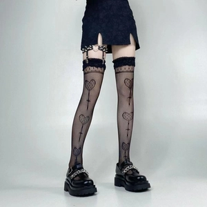 Detail of gothic fishnet stockings with heart patterns and studded leather garters