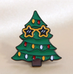Macro shot of green Christmas tree enamel pin with yellow star sunglasses and colorful lights