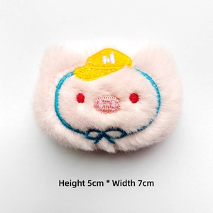 Detail view of 5x7cm pink plush accessory with cute cartoon embroidery and soft texture